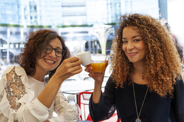 two adorable girls smiling while are toasting