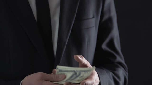 Male hand giving bribe money to businessman, corruption and venality, crime