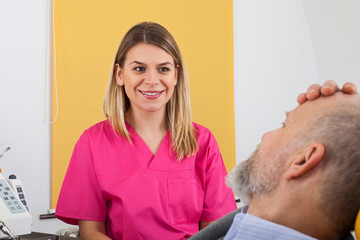 Young female dentist with elderly patient