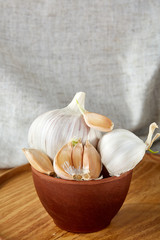 Garlic close up on wooden plate on rustic background, shallow depth of field, selective focus, macro
