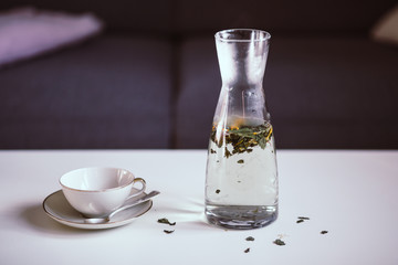 Carafe with herbal tea and a tea cup