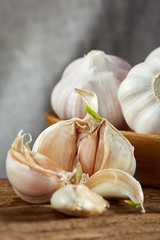Garlic close up on wooden plate on rustic background, shallow depth of field, selective focus, macro