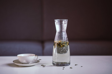 Carafe with herbal tea and a tea cup