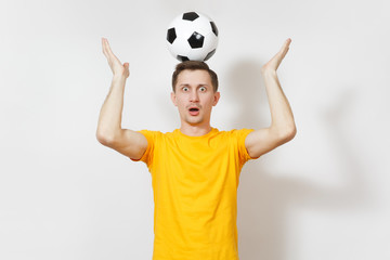 Inspired young fun European man, fan or player in yellow uniform hold on head soccer ball, cheer favorite football team isolated on white background. Sport, play football, healthy lifestyle concept.