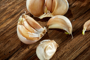 Garlic close up on wooden plate on rustic background, shallow depth of field, selective focus, macro