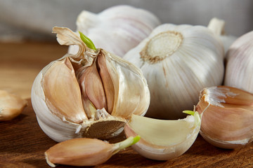 Garlic close up on wooden plate on rustic background, shallow depth of field, selective focus, macro