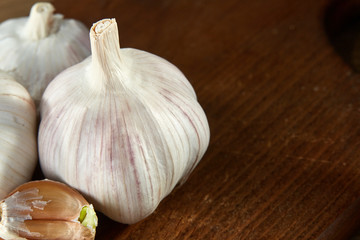 Garlic close up on wooden plate on rustic background, shallow depth of field, selective focus, macro