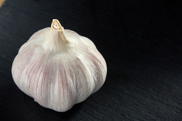 Garlic close up on wooden plate on black board,shallow depth of field, selective focus, macro