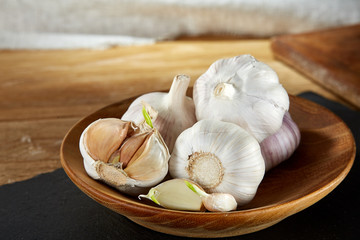 Garlic close up on wooden plate on black board,shallow depth of field, selective focus, macro