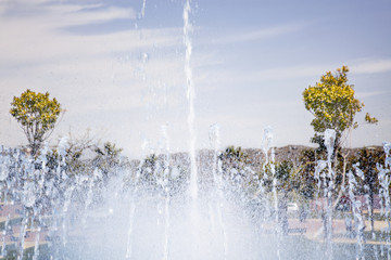 Salpicaduras de agua de la fuente en un día soleado bajo un cielo azul