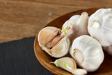 Garlic close up on wooden plate on black board,shallow depth of field, selective focus, macro