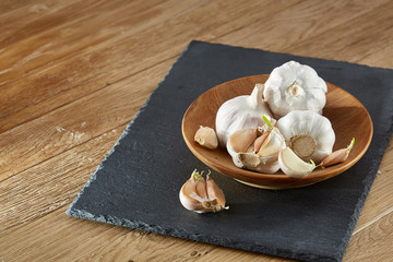Garlic close up on wooden plate on black board,shallow depth of field, selective focus, macro