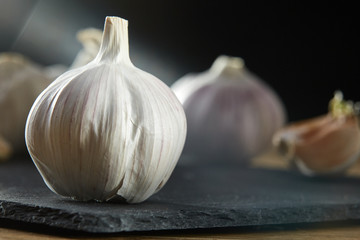 Garlic close up on black piece of board, shallow depth of field, selective focus, macro