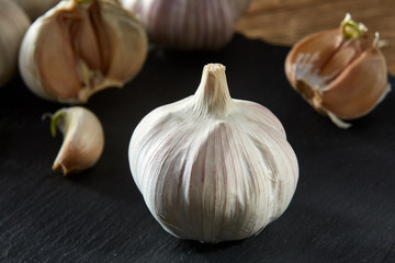 Garlic close up on black piece of board, shallow depth of field, selective focus, macro