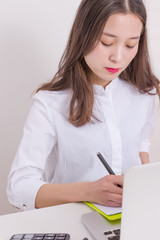 Woman working with laptop computer in office. Thoughtful modern business woman documents in office