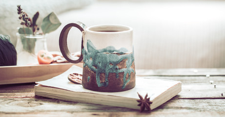 book and a cup of tea on a wooden background