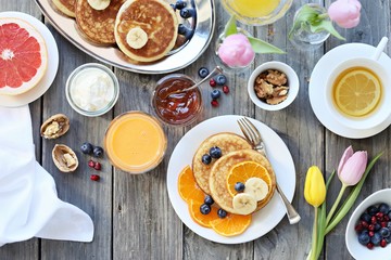 Fototapeta na wymiar Pancakes. Breakfast set with pancakes, fresh berries, banana and various of topping. Overhead view, selective focus