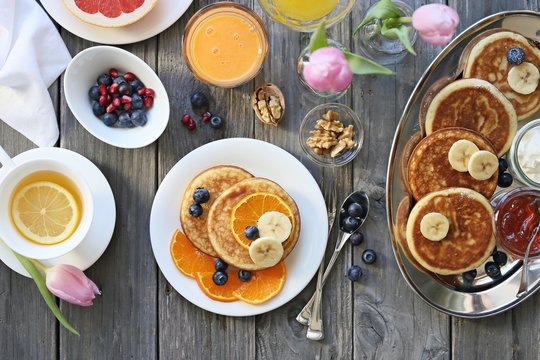 Pancakes. Breakfast set with pancakes, fresh berries, banana and various of topping. Overhead view, selective focus