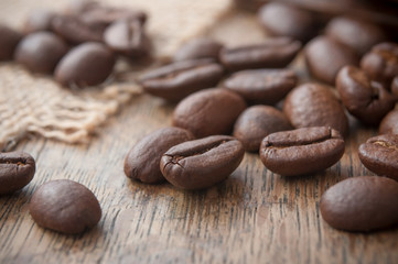 grains de café et toile de jutte sur table en bois