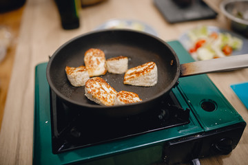 Cheese is fried on cast-iron frying pan, fried cheese, preparation of snacks