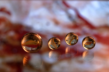 Glass marbles on blurred abstract  red surface