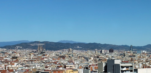 panorama of the city of barcelona showing the cathedral business district and housing with mountains in the distance