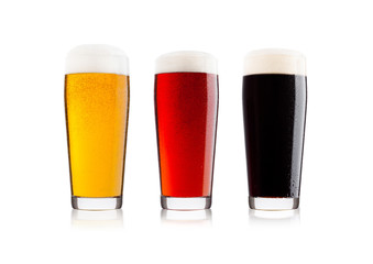 Cold glasses of lager stout and red beer with dew