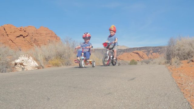 Two young boys riding bikes on a bike path
