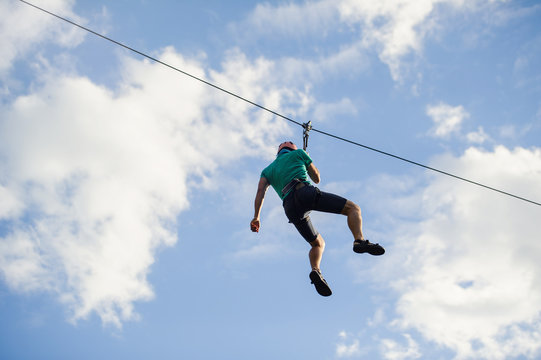 a man descends on a rope, a sport in an extreme park, A man walking along a zip line