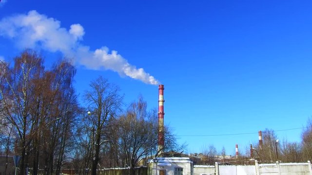 smoke from a chimney factory frosty in the winter against a background of blue sky ecology mud greenhouse effect