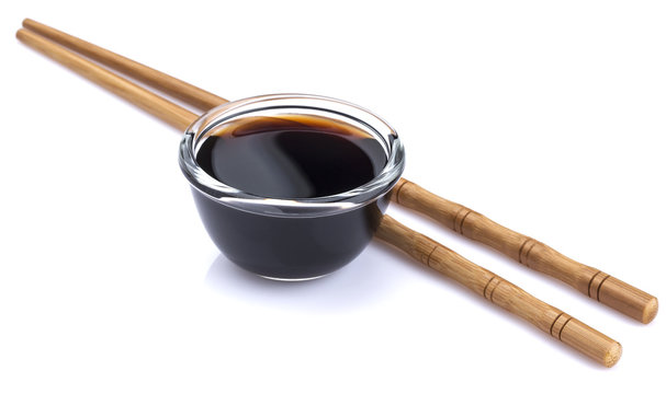 Soy sauce and bamboo chopsticks isolated on white background