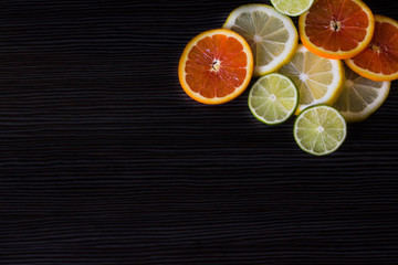 Fototapeta na wymiar lemon, orange and lime on a black background