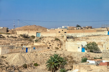 Arab village in the desert of Tunisia with houses from the sand and blue doors