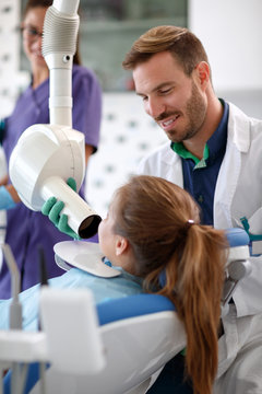 Male dentist holding x-ray tube in dental clinic