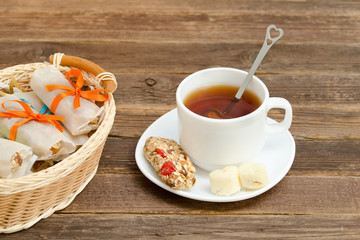Mug of black tea, a bar of muesli and a basket with bars