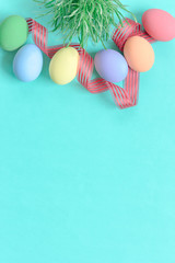 pastel easter eggs on green background in top view