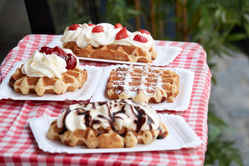 Popular national dish Belgian waffles with strawberries, cherries, chocolate and powder in the tourist town of Bruges