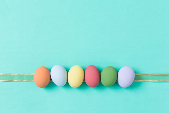 pastel easter eggs on green background in top view