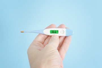 Electronic thermometer in a man's hand. Close up