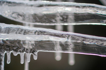 Close up of shiny and white icicles with a dark background