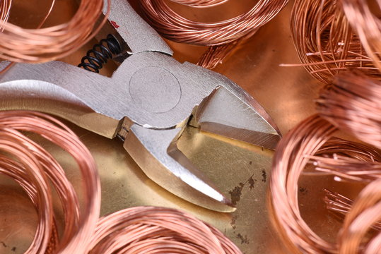 Copper wire scrap and tool pliers closeup