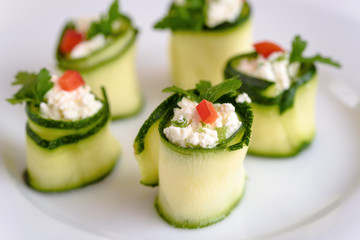 Rolls of zucchini stuffed with cheese and chives and red paprika.