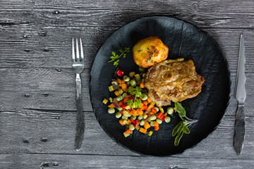 Grilled pork with roasted vegetables and baked potato