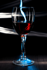 A glass of wine on a bright background with a bokeh effect.