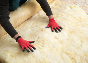 worker insulates the floor with mineral wool