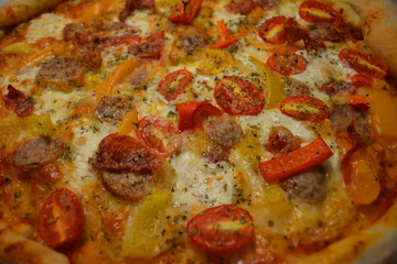 Obraz na płótnie Canvas Delicious Pizza with Mozzarella Cheese, Cherry Tomato, Red Bell Pepper, Onion, and Pork Sausage
