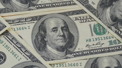 Obraz na płótnie Canvas One hundred dollar bills lying with each other. The motion camera slider. Macro of banknotes. Portrait of Benjamin Franklin - 4