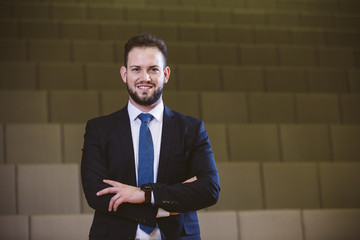 Image of a man dressed in a suit in a congress with empty seats.