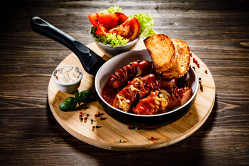 Grilled sausages with toasts on wooden table 