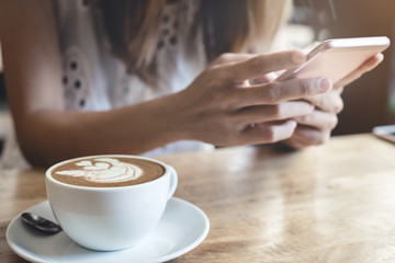 Young woman using smart phone in coffee shop